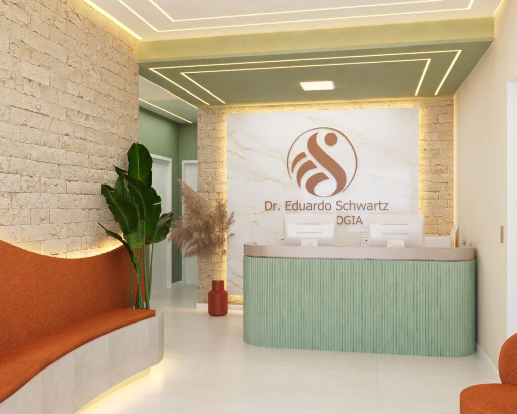 Recepção da Schwartz Odontologia em Canguçu, com balcão verde e bancos estofados em tom terracota.