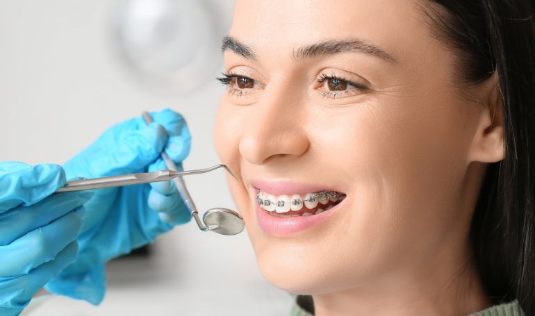 Paciente com aparelho ortodôntico fixo durante avaliação odontológica.